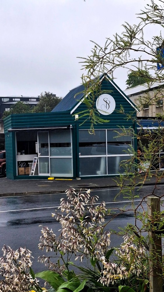 The dark green corner shopfront of SP Hair Therapy on Baxter Street, Warkworth